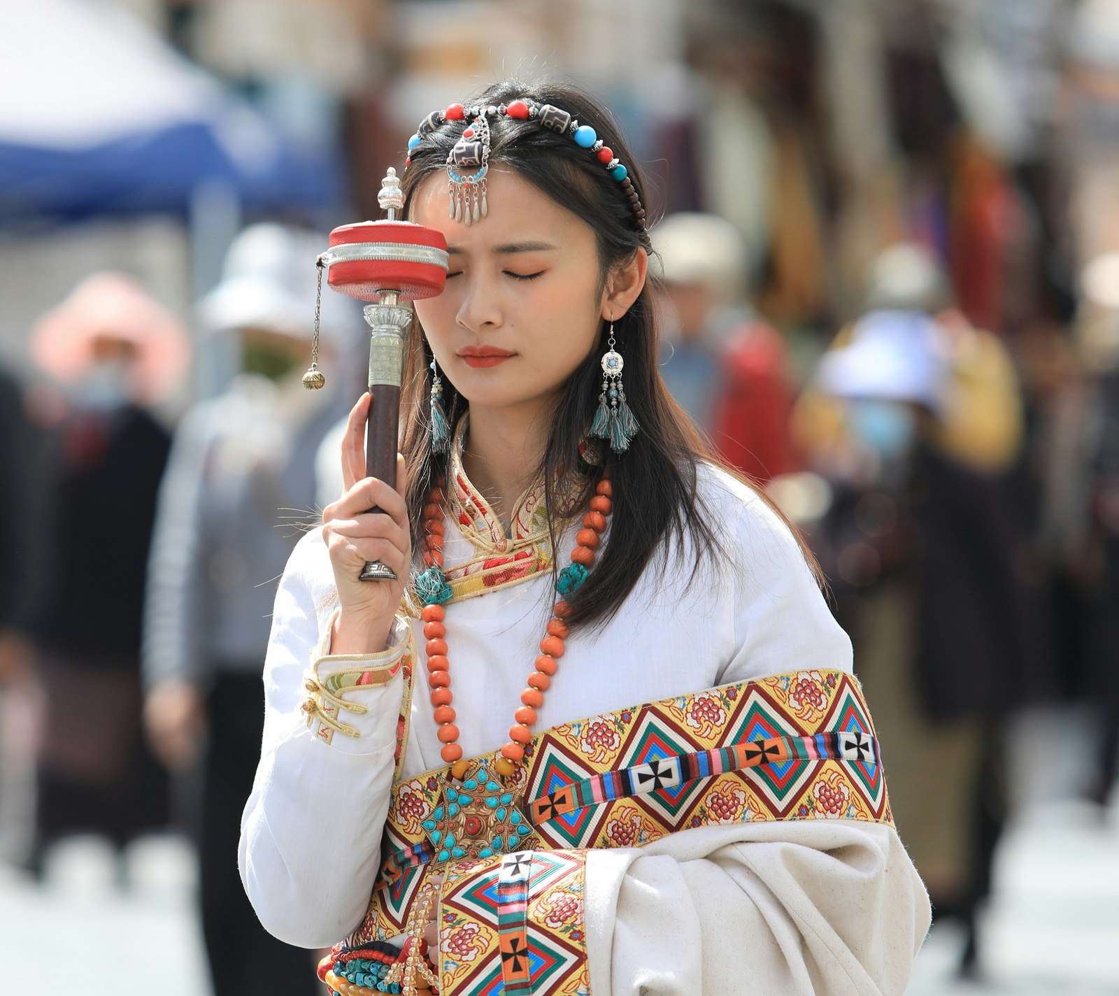 Traditional dress and a prayer wheel