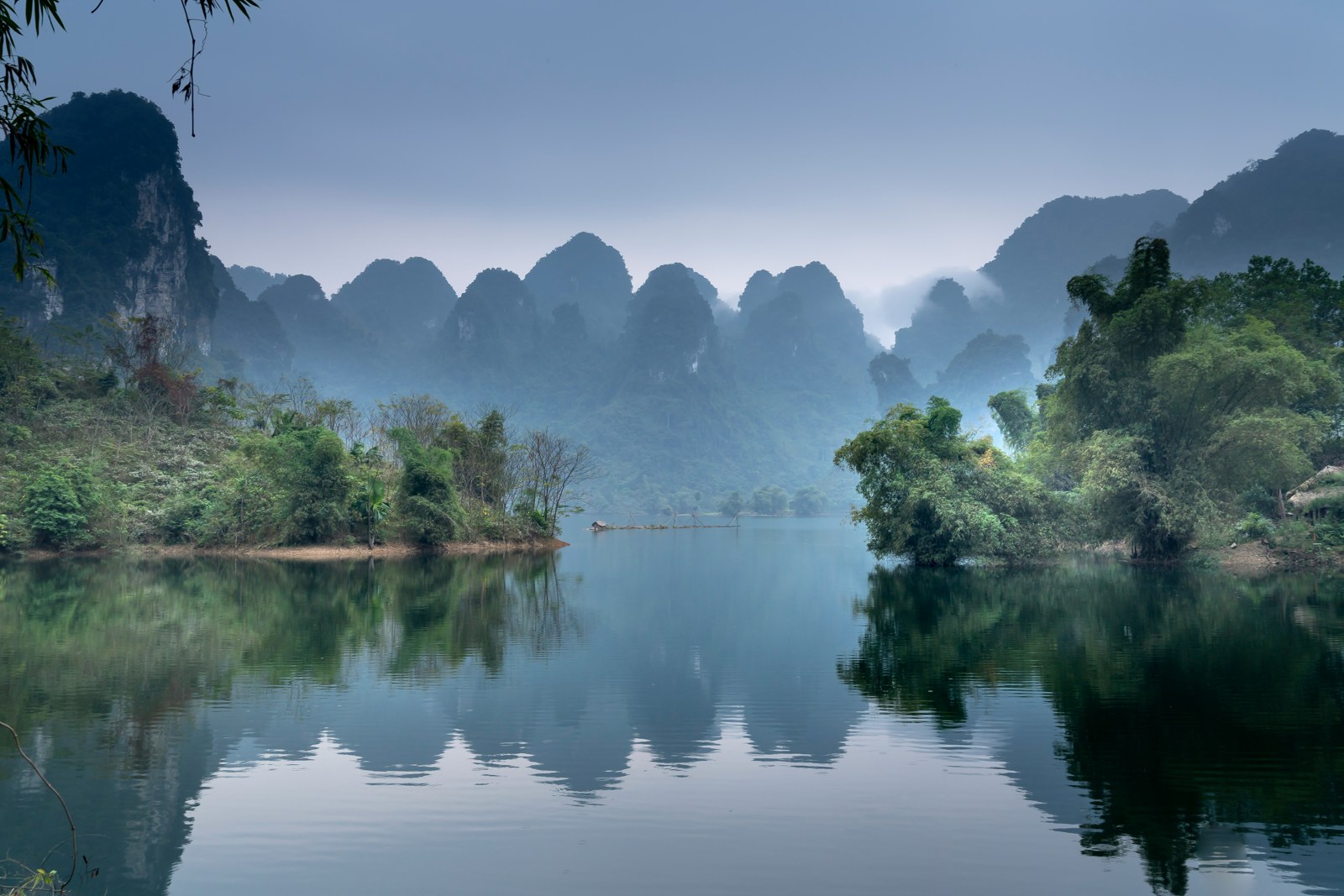Karst mountains reflected in a peaceful river